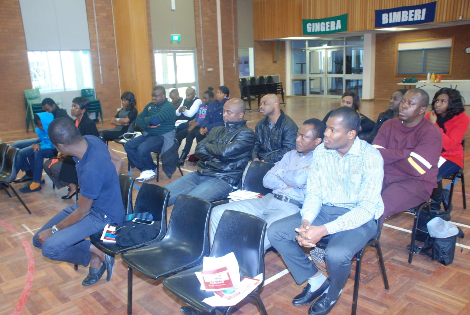 Men of the church seated together, following along during a study session